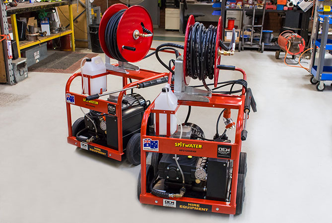 Two spitwater pressure cleaners in a workshop