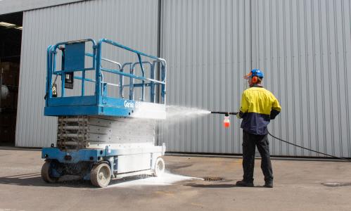 Man foaming a scissor lift for cleaning