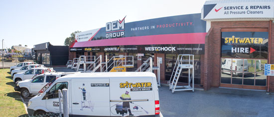 Front of building showing vans, ladders and signage