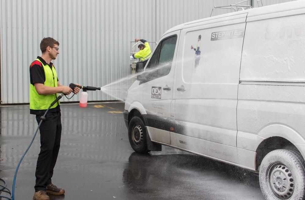 man using foamer to clean van