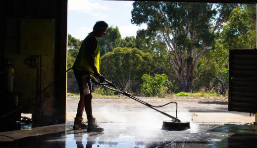 Surface Cleaning a Large Area with a Pressure Cleaner silhouetted
