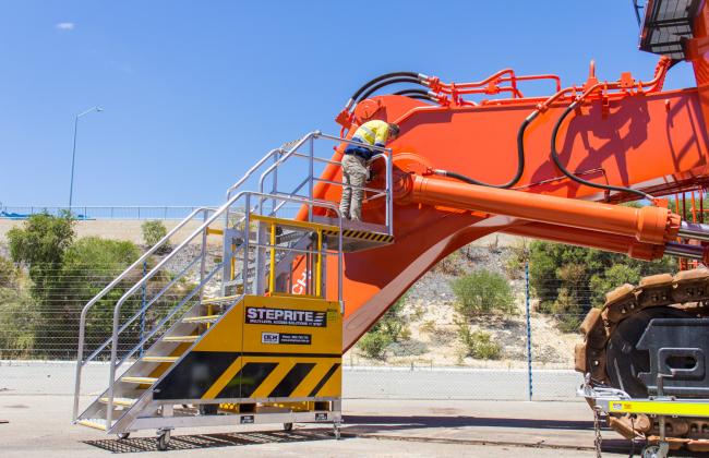 Worker on a Steprite Safety Access Platform working on a large Excavator