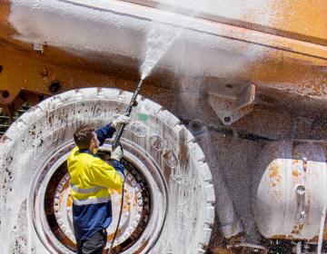 Operator using a SPITWATER Pressure Cleaning Foaming a CAT Truck