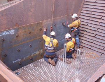workers on a custom platform in a chute